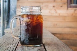 木のテーブルの上に置かれた爽やかなアイスティーのグラス。 木のテーブルの上に置かれた爽やかなアイスティーのグラス。