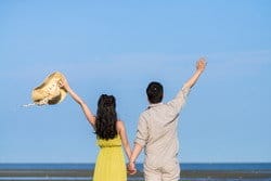 スペインのビーチに男性と女性が手をつないで立っています。