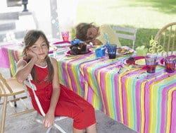 スペインのパーティーテーブルの椅子に女の子が座っています。 スペインのパーティーテーブルの椅子に女の子が座っています。