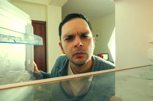 スペインの冷蔵庫の前に立つ男性。