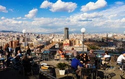 スペインのバルセロナ市を見下ろす屋上のテーブルに座る人々のグループ。 shutterstock_155106467