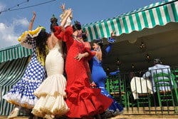 スペインのテントの前で踊るスペインのドレスを着た女性のグループ。