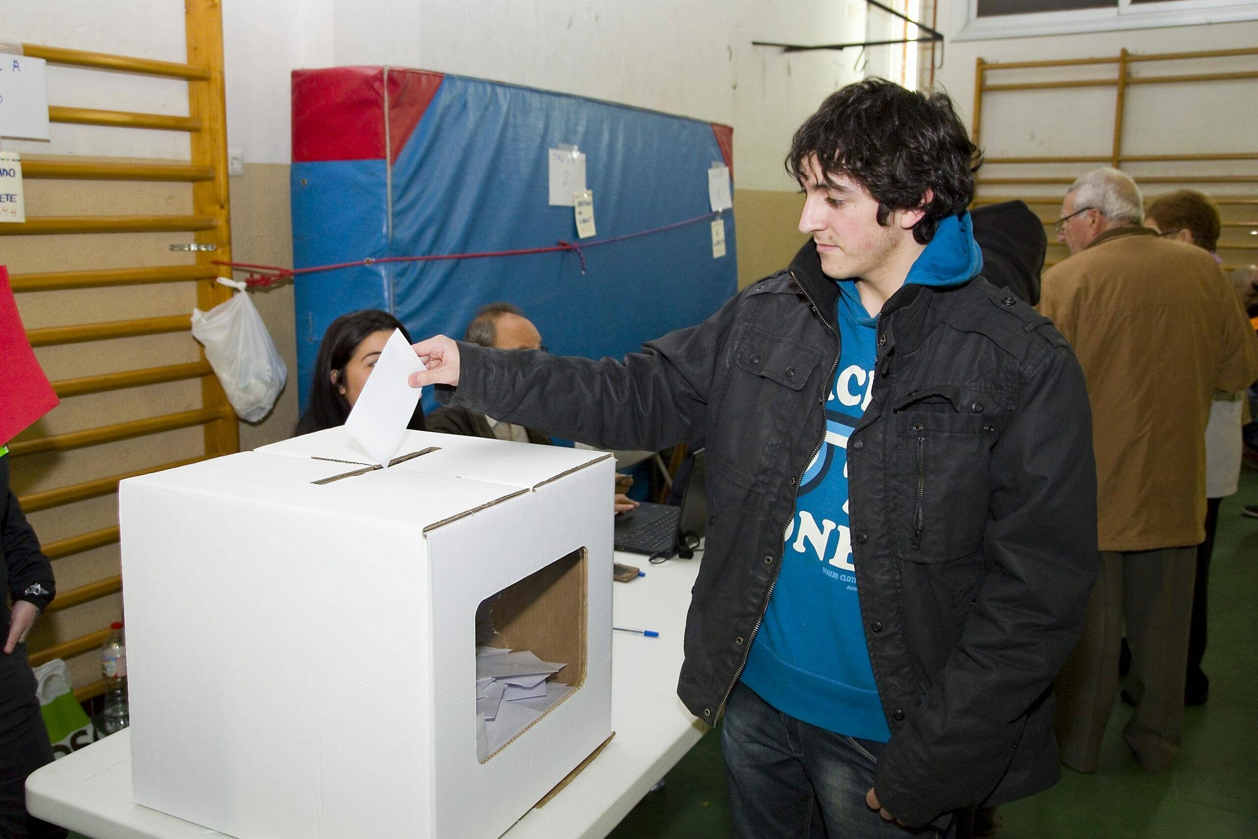 スペインで投票箱に票を入れる男性。