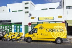 スペインの建物の前に駐車されている3台の黄色いバン。 スペインの建物の前に駐車されている3台の黄色いバン。