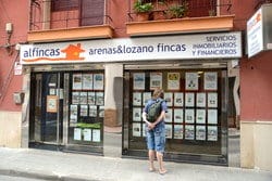 看板のあるスペインの建物の前に立つ男性。 看板のあるスペインの建物の前に立つ男性。