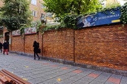 スペインのレンガの壁のある通りを歩く人々のグループ。