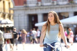 スペインの賑やかな街で自転車に乗る若い女性。 スペインの賑やかな街で自転車に乗る若い女性。