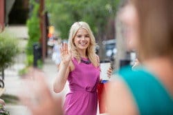 女性が道を歩いていて、スペインから来た別の女性に手を振っています。 女性が道を歩いていて、スペインから来た別の女性に手を振っています。