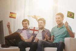 スペインの国旗を持ってソファに座っている人々のグループ。 スペインの国旗を持ってソファに座っている人々のグループ。