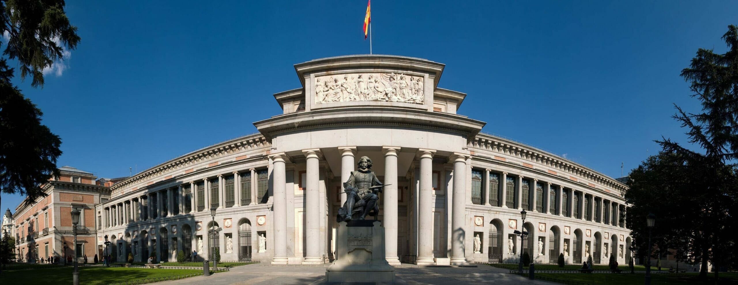 柱とその前に彫像があるスペインの建物。