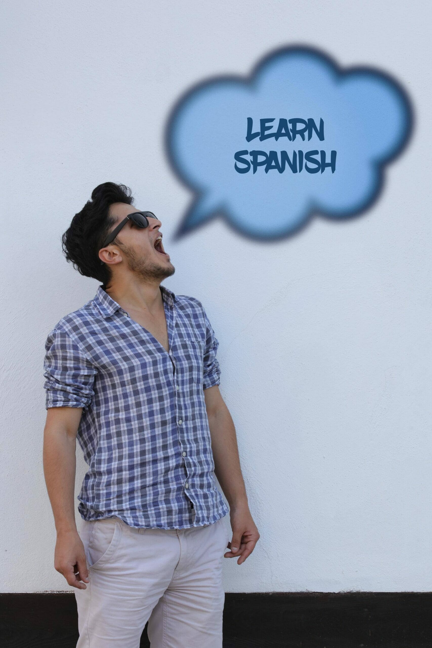 男性が「スペイン」という単語が書かれた吹き出しを見上げています。