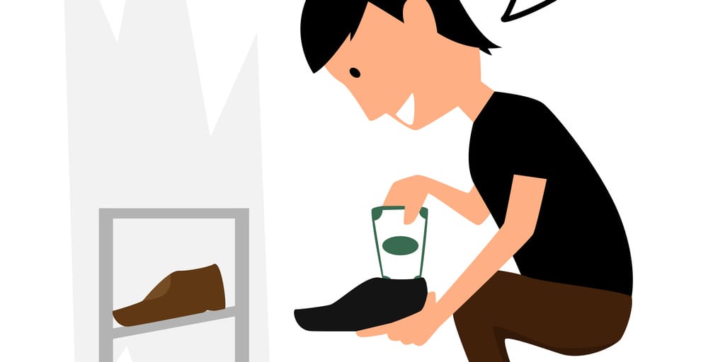 スペインで靴にお金を入れる男性。