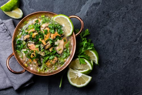 スペインの暗い背景に野菜とライムが入ったスープのボウル。 スペインの暗い背景に野菜とライムが入ったスープのボウル。