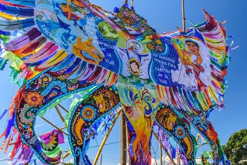 青い空の前のポールにカラフルなスペインの凧。