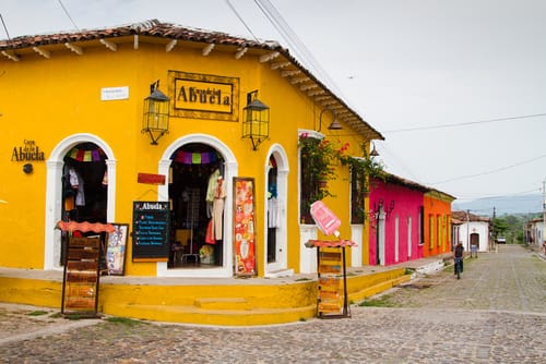 スペインの石畳の通りにある黄色い建物。 スペインの石畳の通りにある黄色い建物。