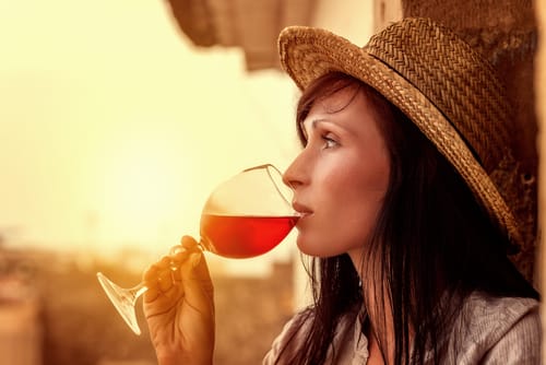 スペインをイメージした麦わら帽子をかぶって赤ワインを飲む女性。 スペインをイメージした麦わら帽子をかぶって赤ワインを飲む女性。