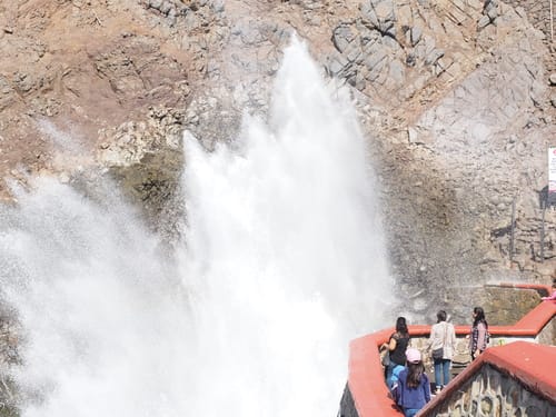 スペインの滝の隣に立つ人々のグループ。 スペインの滝の隣に立つ人々のグループ。