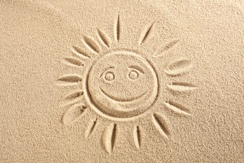 スペインのビーチの砂浜に太陽が描かれています。 スペインのビーチの砂浜に太陽が描かれています。