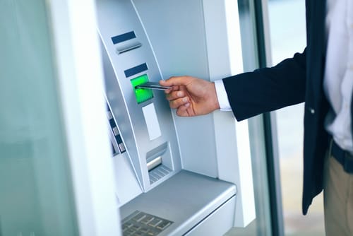 男性がスペインの ATM にお金を入れています。 男性がスペインの ATM にお金を入れています。