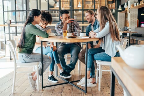 スペインのカフェでテーブルの周りに座っている人々のグループ。