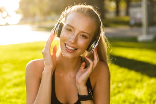 スペインの穏やかな雰囲気を楽しみながら、公園で音楽を聴く若い女性。 スペインの穏やかな雰囲気を楽しみながら、公園で音楽を聴く若い女性。