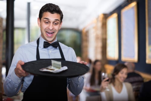 レストランでトレイを持っているスペインのウェイター。 レストランでトレイを持っているスペインのウェイター。
