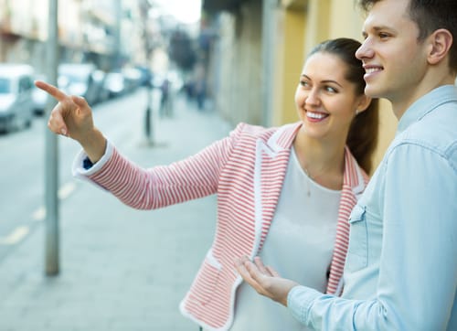 路上で何かを指差す男性と女性。 路上で何かを指差す男性と女性。