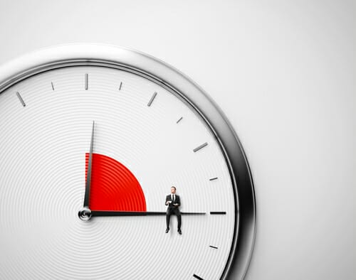 スペインで男性が時計の上に立っています。 スペインで男性が時計の上に立っています。