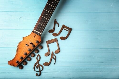 青い木の背景にスペインのギターと音符。 青い木の背景にスペインのギターと音符。