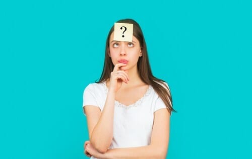 スペインの若い女性が頭に疑問符を持っています。 スペインの若い女性が頭に疑問符を持っています。