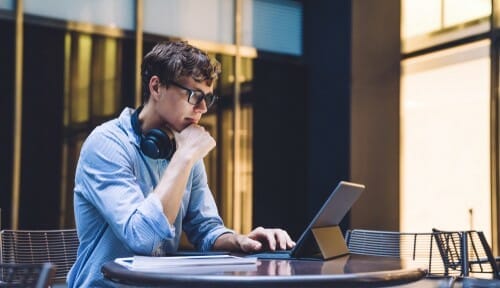 スペインでテーブルに座ってラップトップを使用している男性。 スペインでテーブルに座ってラップトップを使用している男性。