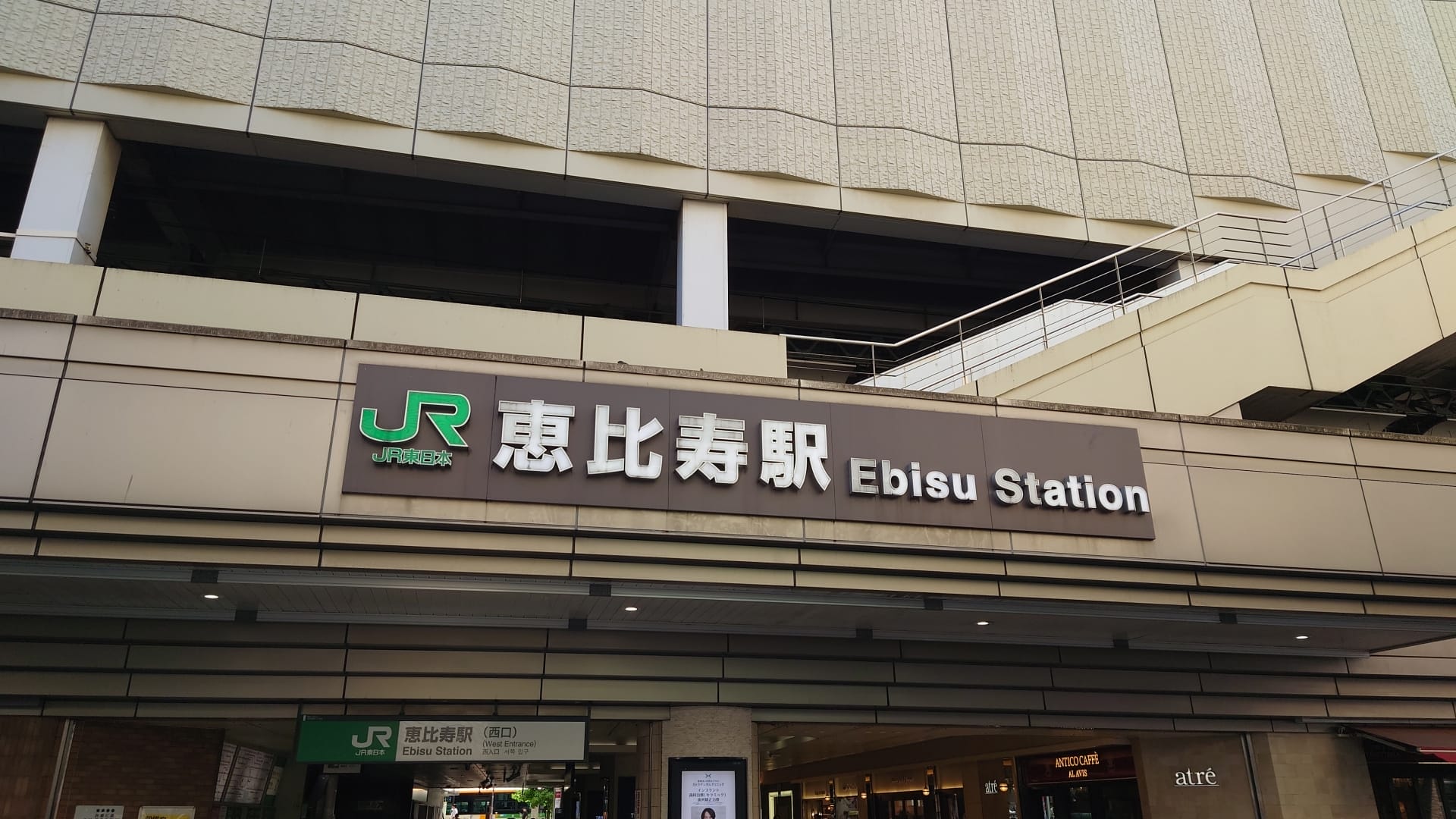 恵比寿駅の入り口には、日本語と英語で駅名を表示した看板があり、活気あふれるエリアの探索を促します。近くには、新しい文化に浸れるようにカスタマイズされた個別の言語学習を提供するスペイン語教室マンツーマンがあります。.